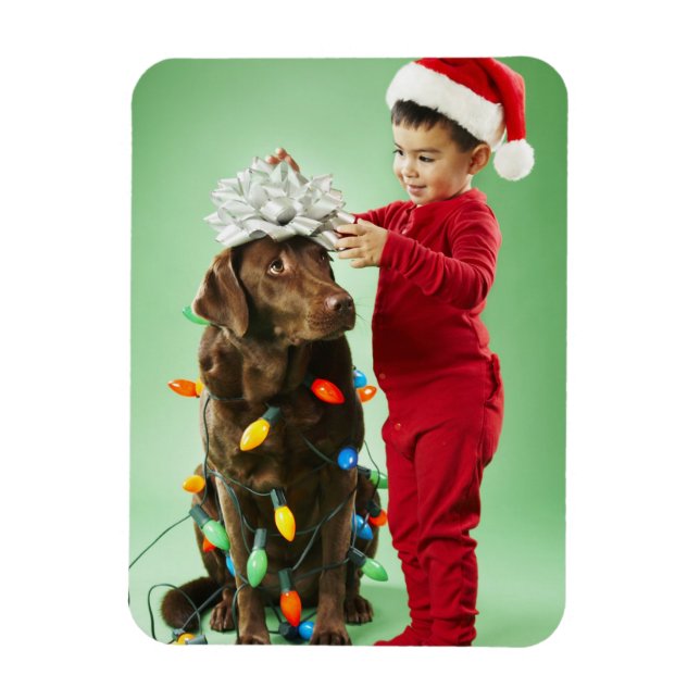 Junge Junge packt Weihnachtsleuchten um einen Hund Magnet (Vertikal)