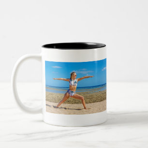 Junge Kaukasierin in Yoga-Pose am Strand.JPG Zweifarbige Tasse