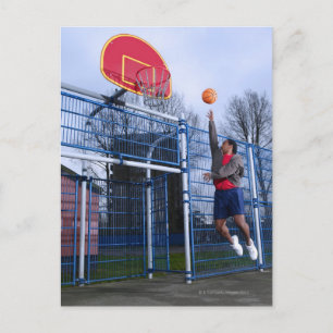 Junge Mann spielt Basketball im Freien Postkarte