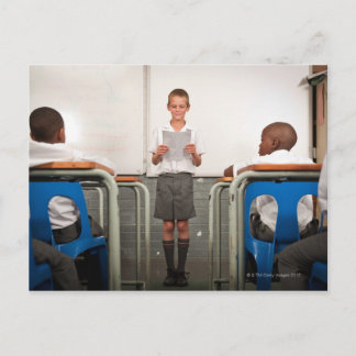 Junge stehend vor der Klasse lesen in Postkarte