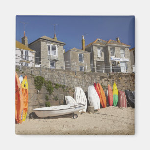 Kajaks und Dinghien, die an der Wand des Meeres Magnet