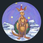 Kangaroo Christmas Starry Night Runder Aufkleber<br><div class="desc">Tierparade Festival Kangaroo und Baby Roo Geschenke und Accessoires bieten unser bezauberndes Mama Kangaroo und Baby Zimmer mit roten Weihnachtsmannmützen. Von hinten trägt Mama einen riesigen heiligen Kranz und flüchtige Blicke im Babyraum. Dieses niedliche Kangaroo liegt in einer schneebedeckten Landschaft mit einem Sternenhimmel und einer spielerischen, welligen Grenze. Lass diesen...</div>