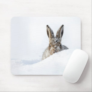 Kaninchen schaut über eine Schneeverwehung Mousepad