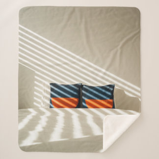 Karierte, schwarzweiße Textilien auf weißem Bett Sherpadecke