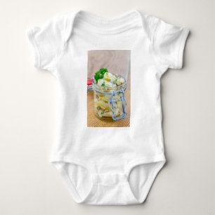 Kartoffelsalat in einem Glas auf Holz Baby Strampler