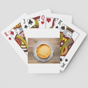 Käsekuchen auf rustikalen Holzkuchen oben. Spielkarten