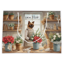 Katze arrangiert Winterblumen für Weihnachten