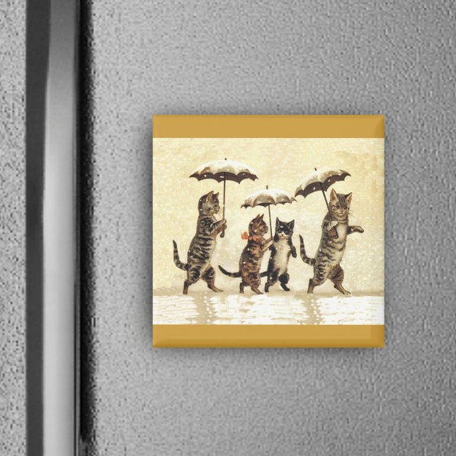 Katze Familie mit Schneeschuhwandern Magnet (Four brown cats walking upright in snow with umbrellas on yellow square magnet.)