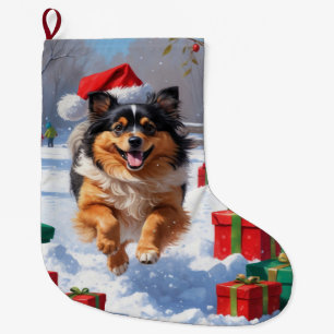Keeshond-Hund läuft im Schnee mit Weihnachtsmütze Großer Weihnachtsstrumpf