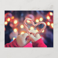 Kind, das Weihnachtssüßigkeit mit Herzform hält