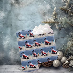 Kind sieht Santa Claus an, am Strand sitzen Geschenkpapier