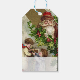 Kinder, die Stechpalme mit Vintagem Weihnachtsmann Geschenkanhänger