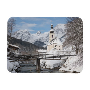 Kirche im Schnee mit den Alpen im Winter Magnet