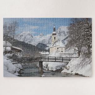 Kirche im Schnee mit den Alpen im Winter Puzzle