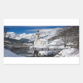 Kirche im Schnee mit den Alpen Rechteckiger Aufkleber