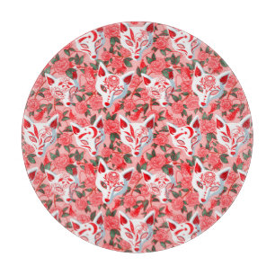 Kitsune Masken und blühende Kamelie auf rosa Schneidebrett