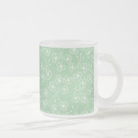 Kleeblätter in Weiß auf der Tasse aus grünem Glas