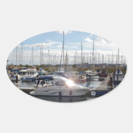 Kleines Motorboot, das die Sonne fängt Ovaler Aufkleber