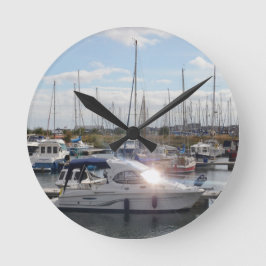 Kleines Motorboot, das die Sonne fängt Runde Wanduhr