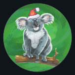 Koala Bear Christmas Runder Aufkleber<br><div class="desc">Feierliche Weihnachtslieferungen aus dem Koala-Bären zeigen unseren kuscheligen Koala-Bär mit einer Weihnachtsmannmütze. Viele unserer lustigen Urlaubsprodukte zeigen auch unser niedliches Koala von hinten mit — überraschend! — Baby Koala mit einem heiligen Kranz. Viele Designs haben auch ein Weihnachtsgrün mit unserer Signatur-Textur. Genießen Sie die Shoppingsaison mit unseren niedlichen und kuscheligen...</div>