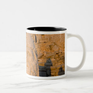Kolossale Kopfstatuen von Göttern bewachen den Zweifarbige Tasse