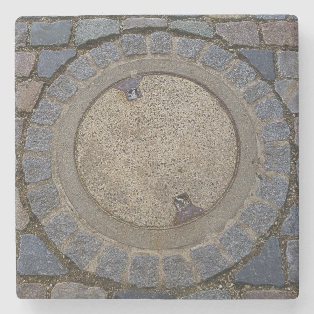 Kopfsteinpflasterstraße mit Manhole, grau-braun Steinuntersetzer (Vorderseite)