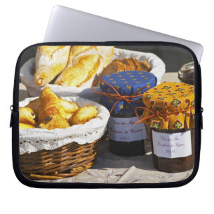 Korb mit Croissants und Schokoladenbroten. Laptopschutzhülle