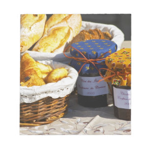 Korb mit Croissants und Schokoladenbroten. Notizblock