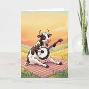 Kuh zum Geburtstag spielt Banjo auf einer Decke Karte
