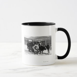 Kuhmannschaft, die Männer in einem Wagen zieht Tasse