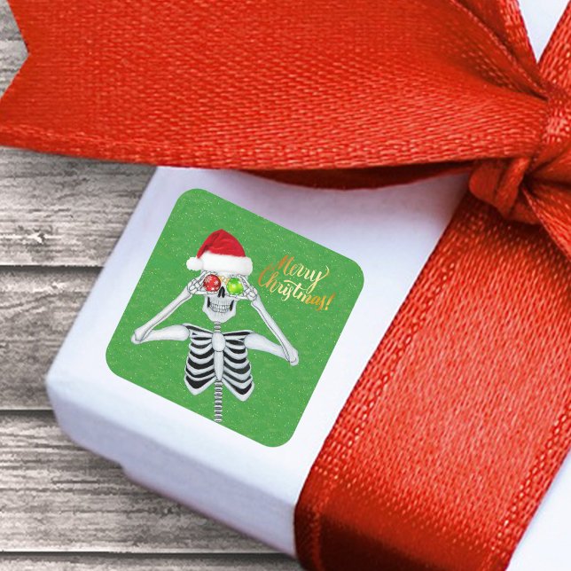 Lächeln Weihnachten Skelett Ornament Augen auf Grü Quadratischer Aufkleber (Funny Merry Christmas Skeleton ornament eyes Santa Hat on green with gold flecks paper sticker.)