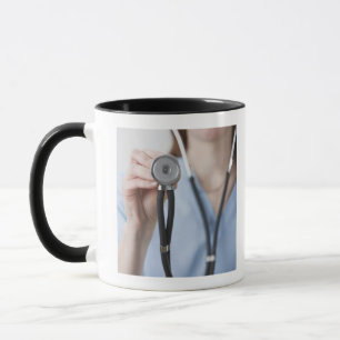 Lächelnder weiblicher Doktor mit Stethoskop Tasse