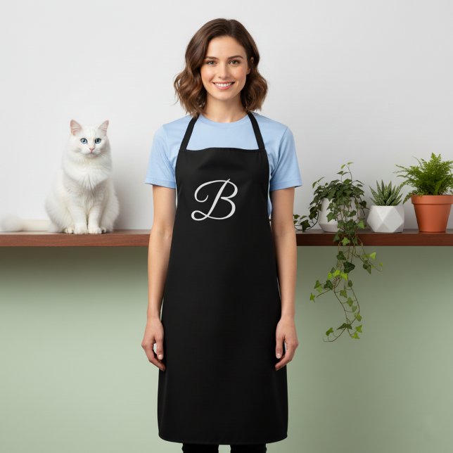 Lange massive schwarze monogrammierte Schürze (Black apron with large monogram.)