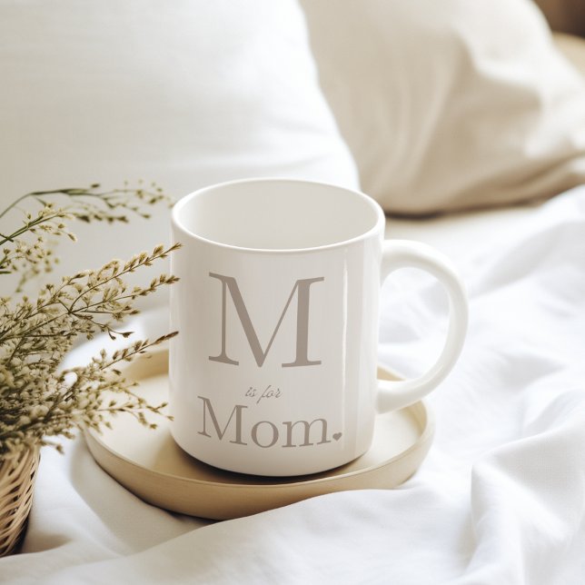 Layout des Liebe Kaffeetasse (“White mug with taupe lettering, oversized serif initial, script accent, bold ‘Mom,’ and heart.”)