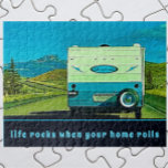 Leben stürzt ab, wenn Ihre Zuhause Vintage Camper  Puzzle<br><div class="desc">Ein Vintager Wohnwagen, der in die Berge in der Ferne führt, ist der Rahmen für Abenteuer auf der Straße. Der unterhaltsame Retro RV Camping Trailer ist blau und cremeweiß mit Highlights von grün. Unter dem Camper ist eine Vorlage, die lautet: Leben Steine, wenn Ihre Zuhause rollt. Die Textvorlage ist leicht...</div>