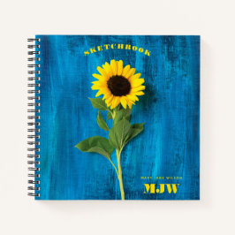 Lebhafte Sonnenblume und Monogramm auf blauem Hint Notizbuch