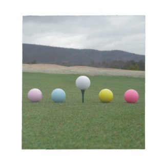 leuchtend farbige Golfbälle auf einem Berg Notizblock