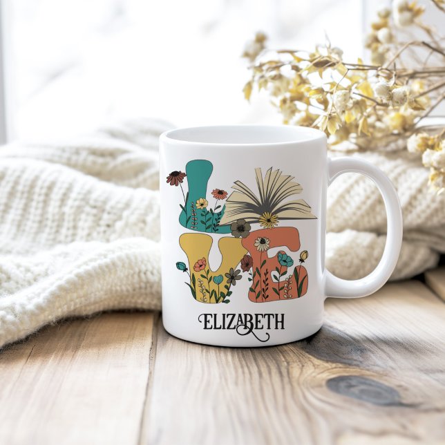 LIEBE Bücher Individuelle Name Retro-Wildblumen Kaffeetasse (LOVE Books Custom Name Retro Wildflowers Coffee Mug on a neutral cozy wooden table.)