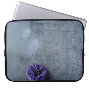 Lila gebogene Blume auf grauer Oberfläche Laptopschutzhülle