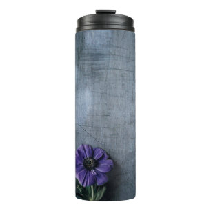 Lila gebogene Blume auf grauer Oberfläche Thermosbecher