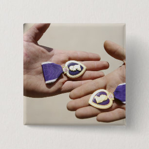 Lila Herzempfänger zeigen ihre Medaillen an Button