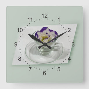 Lila weiße Blume in einer Tasse Quadratische Wanduhr