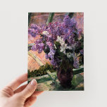Lilacs in einem Fenster | Mary Cassatt Postkarte<br><div class="desc">Lilacs in a Window (1880) von Mary Cassatt ist ein zartes Stillleben Gemälde, das eine Vase mit pulsierenden Lilacs in der Nähe eines Fensters zeigt. Das Kunstwerk erfasst die Schönheit der frischen Blüten und das sanfte Licht, das durch das Glas strömt, und ruft ein Gefühl der Ruhe hervor. Cassatts sorgfältige...</div>