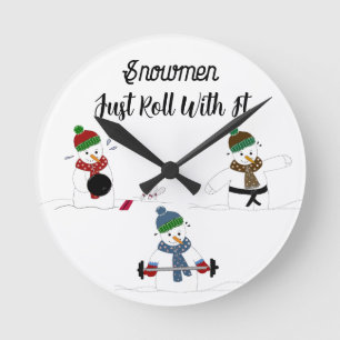 Lustige Schneemänner beim Training Runde Wanduhr