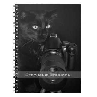 Lustige schwarze Katze mit der Kamera Notizblock