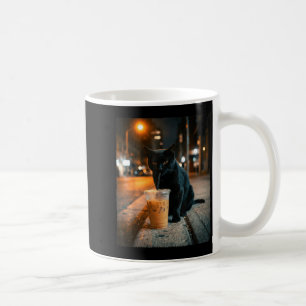 Lustige schwarze Katze trinkt eisgekühlten Kaffee, Kaffeetasse