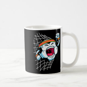 Lustiger Cartoon-Fußball, der das Netz zerreißt un Kaffeetasse