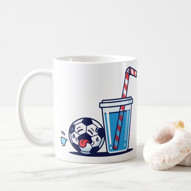 Lustiger durstiger Fußball, der ein kaltes Wasserg Kaffeetasse (Mit Donut)