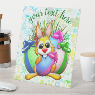 Lustiger Hase, der ein Osterei beißt Sockelschild