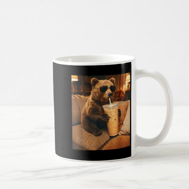 Lustiger Tierbär, der auf dem Sofa Eiskaffee trink Kaffeetasse (Rechts)